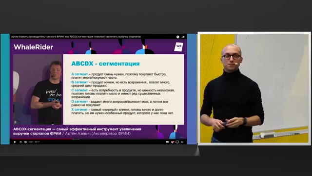 46:18 — Слева остаётся слайд о сегментации ABCDX, справа спикер стоит перед белой доской, держа в