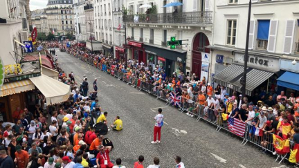 Depuis un balcon, une vue plongeante sur la rue Lepic et les coureurs